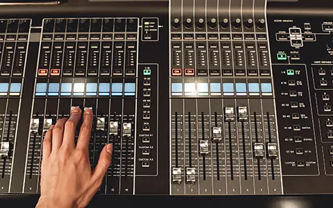 Professional sound control. Close-up view of male hand mixing sounds on digital audio mixing console. Media production. Media production studio. Music record service